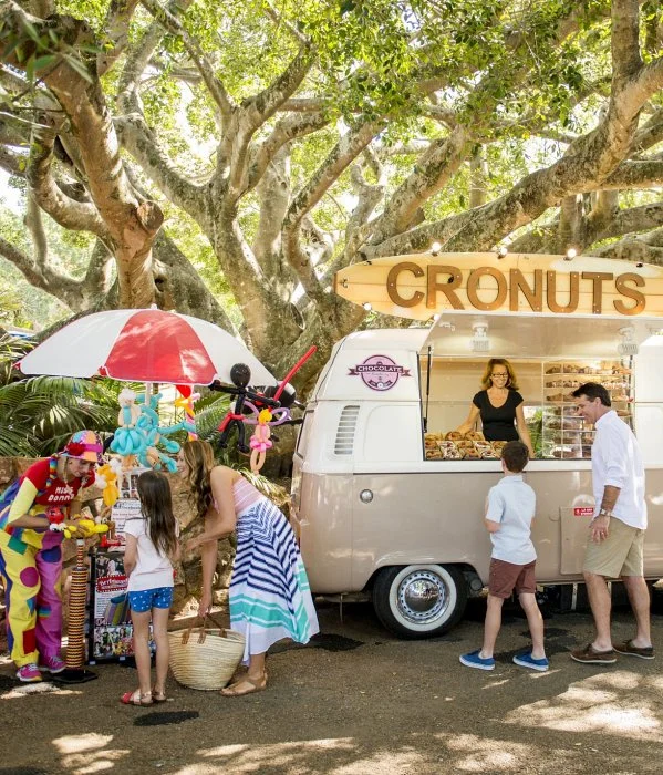 A group of people standing in front of a food truck during a sunshine coast day trip.