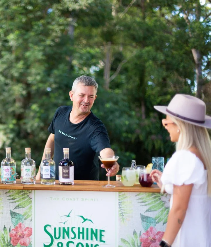 A woman is pouring a drink at a bar on the Sunshine Coast.