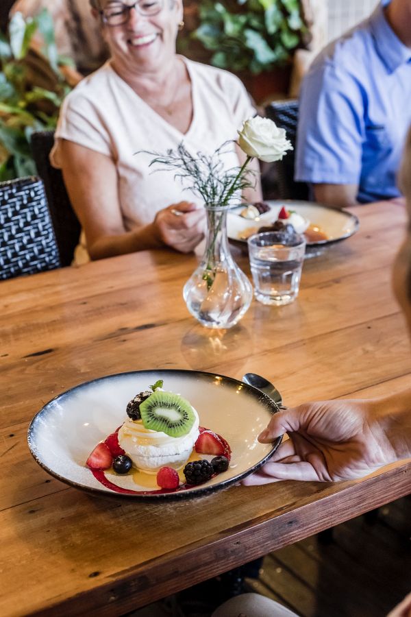 A group of people enjoying a plate of food during Noosa tour.